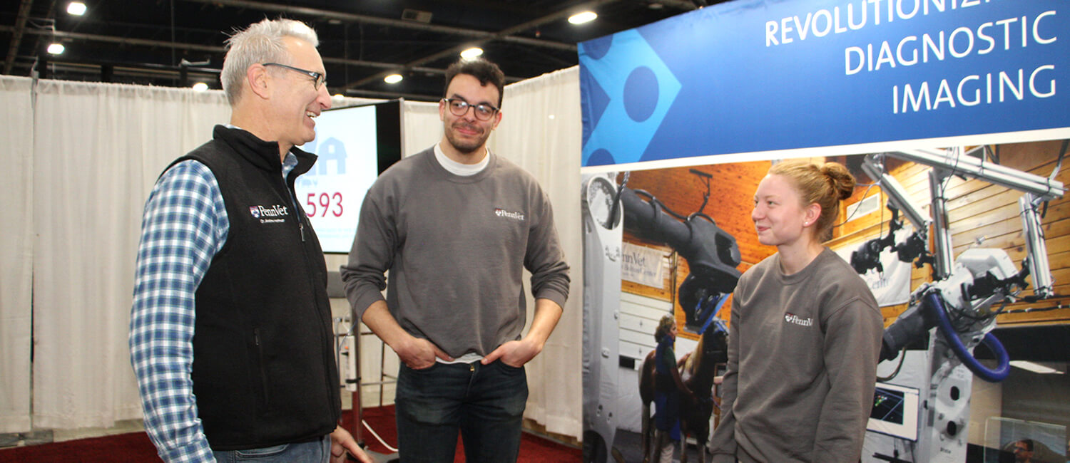 Penn Vet Dean Andrew Hoffman talks with Penn Vet students Robert Sander and Kaitlyn Dreese at the Pennsylvania Farm Show.