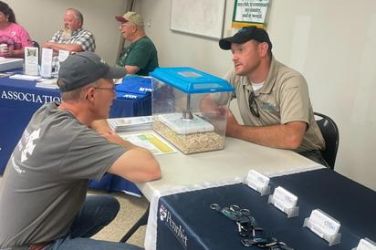 Two people at a table talking about a display